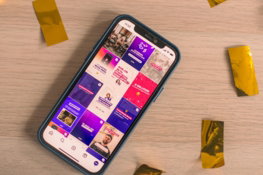 A phone displays a colorful social media feed.
